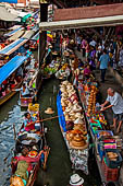 Thailand, Locals sell fruits, food and products at Damnoen Saduak floating market near Bangkok